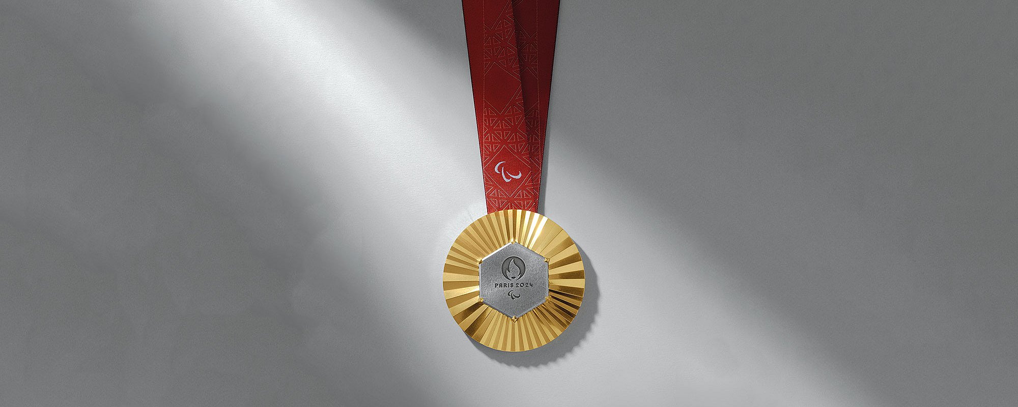 Foto: Goldmedaille der Paralympischen Spiele 2024 mit einem Stück Eiffelturm in der Mitte